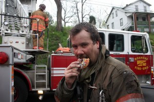 Captain Brown working the turntable on Ladder 1 while Lt. Randy Smith enjoys a doughnut. Photo courtesy of Mike Overacker